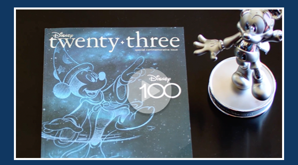 Video thumbnail image of a Disney twenty-three Disney100 edition cover and a Mickey Mouse Milestone statue sitting side by side on a table.