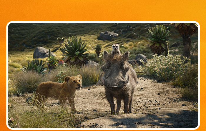From The Lion King (2019), young Simba (voiced by JD McCrary), walks alongside Pumbaa (voiced by Seth Rogen), and Timon (voiced by Billy Eichner).