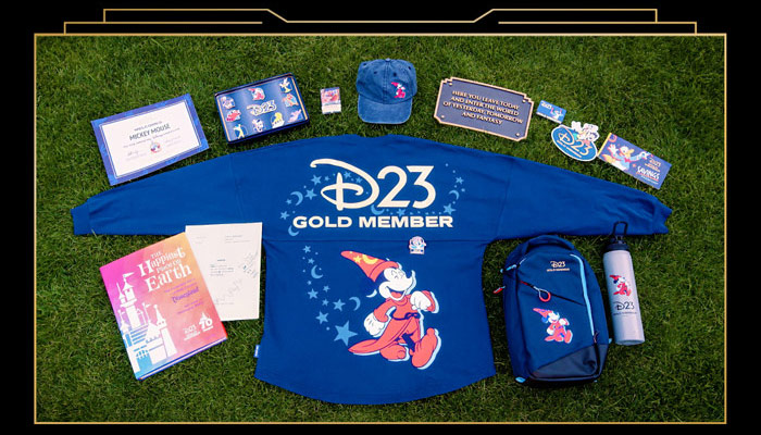 D234 Gold Member kit displayed on grass featuring Mickey Mouse Spirit Jersey, backpack, water bottle, hat, pins, collectible items.