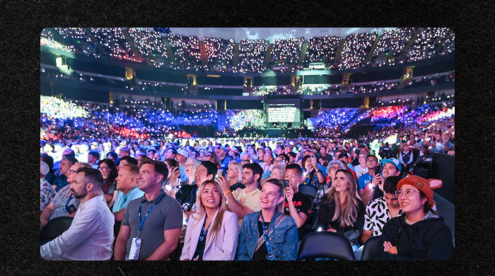 D23 Expo attendees fill a packed arena during a Disney presentation.