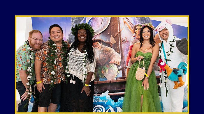 D23 Fans posing for a picture they are dressed in Moana-theme costumes.