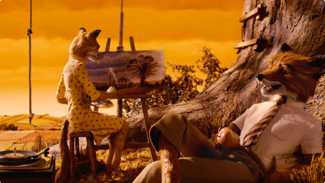 In a scene from Fantastic Mr. Fox, Mrs. Fox sits on a stool, painting a canvas. Nearby, Mr. Fox lounges by a tree, holding a bitten apple in his right hand.
