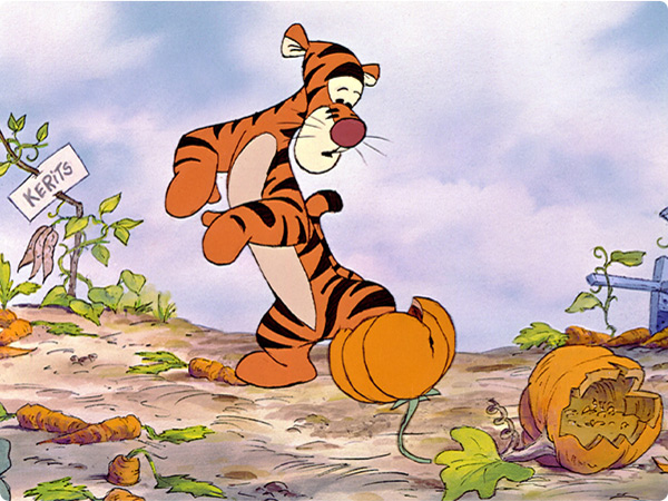 From the animated film Winnie the Pooh and Tigger Too, Tigger stands in a ruined vegetable garden. He has a worried look on his face as he looks down at his feet, one of which is stuck in a broken clay pot. Around him on the ground are broken carrots and pumpkins and two sticks that have paper labels attached at the top, one for carrots and one for pumpkins, both of which are misspelled.