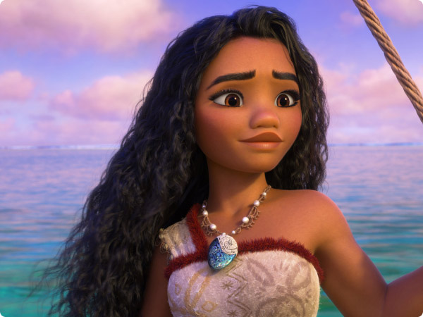 Moana gazes into the distance on the ocean. She wears a Polynesian outfit and a blue pendant necklace, with waves and sky behind her.