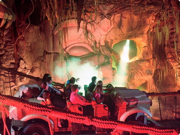 Indiana Jones Adventure ride at Disneyland. Guest in a rugged jeep enter a cave with a glowing, ancient stone face.