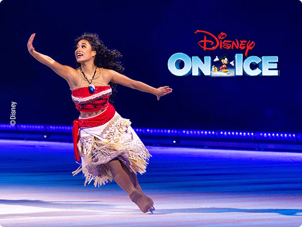 Moana Ice Skater performing at Disney On Ice, she wears Moana's signature outfit and skates gracefully with the Disney On Ice logo behind her.