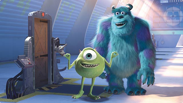 Mikey and Sulley at Monsters, Inc Factory. The two beloved Pixar Characters stand in front of a monster door, smiling.
