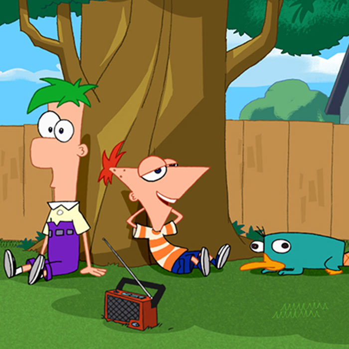 Phineas, Fern, Perry relax beneath a backyard tree, radio playing at their feet.