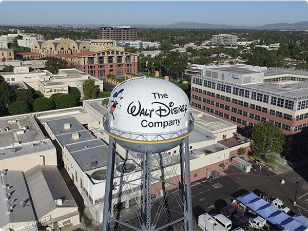 Walt Disney Studios water tower with Mickey and “The Walt Disney Company” logo, aerial view of Burbank lot.