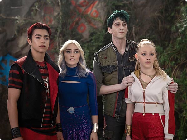 Zombies teen heroes Zed, Addison, Willa and Eliza tensely together in a forest ruin, eyes fixed ahead.
