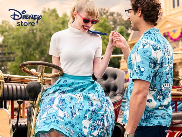 Vintage-styled couple in carriage wearing matching blue Disneyland-70 map prints; corner logo says “Disney Store”