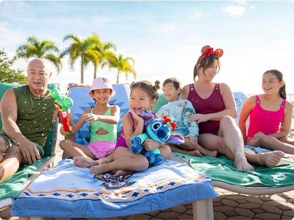 Family relaxing poolside with Stitch Plush at Disney’s Aulani Resort.