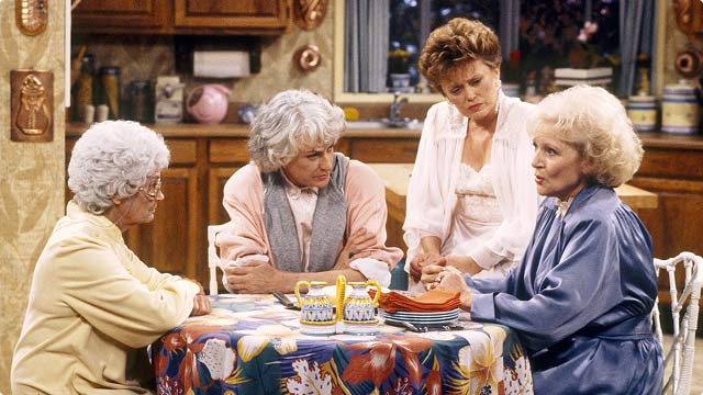 Golden Girls kitchen scene with Bea Arthur, Rue McClanahan, Estelle Getty, and Betty White seated around the table.