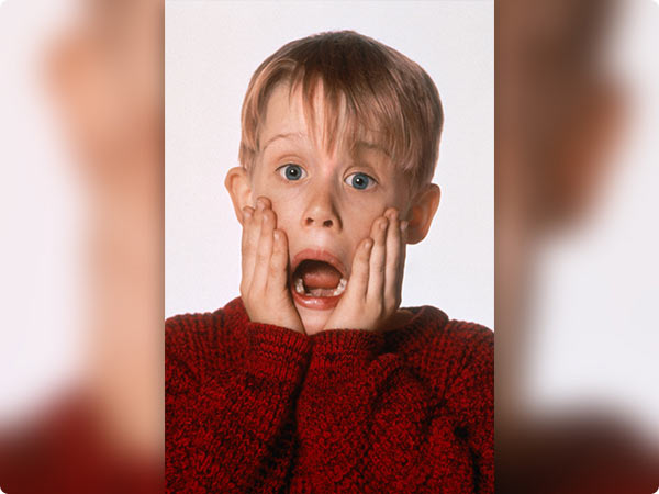 Caramel Apple Beignet: a Halloween pastry with white frosting and orange, black, and purple sprinkles on a wooden board.