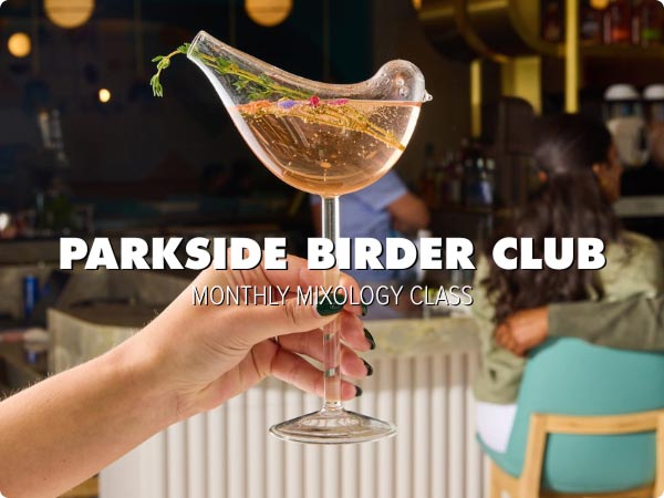 A hand holds up a stemmed wine glass shaped like a bird, with an opening in the “tail” for sipping. White text reads “PARKSIDE BIRDER CLUB, MONTHLY MIXOLOGY CLASS” in the middle.